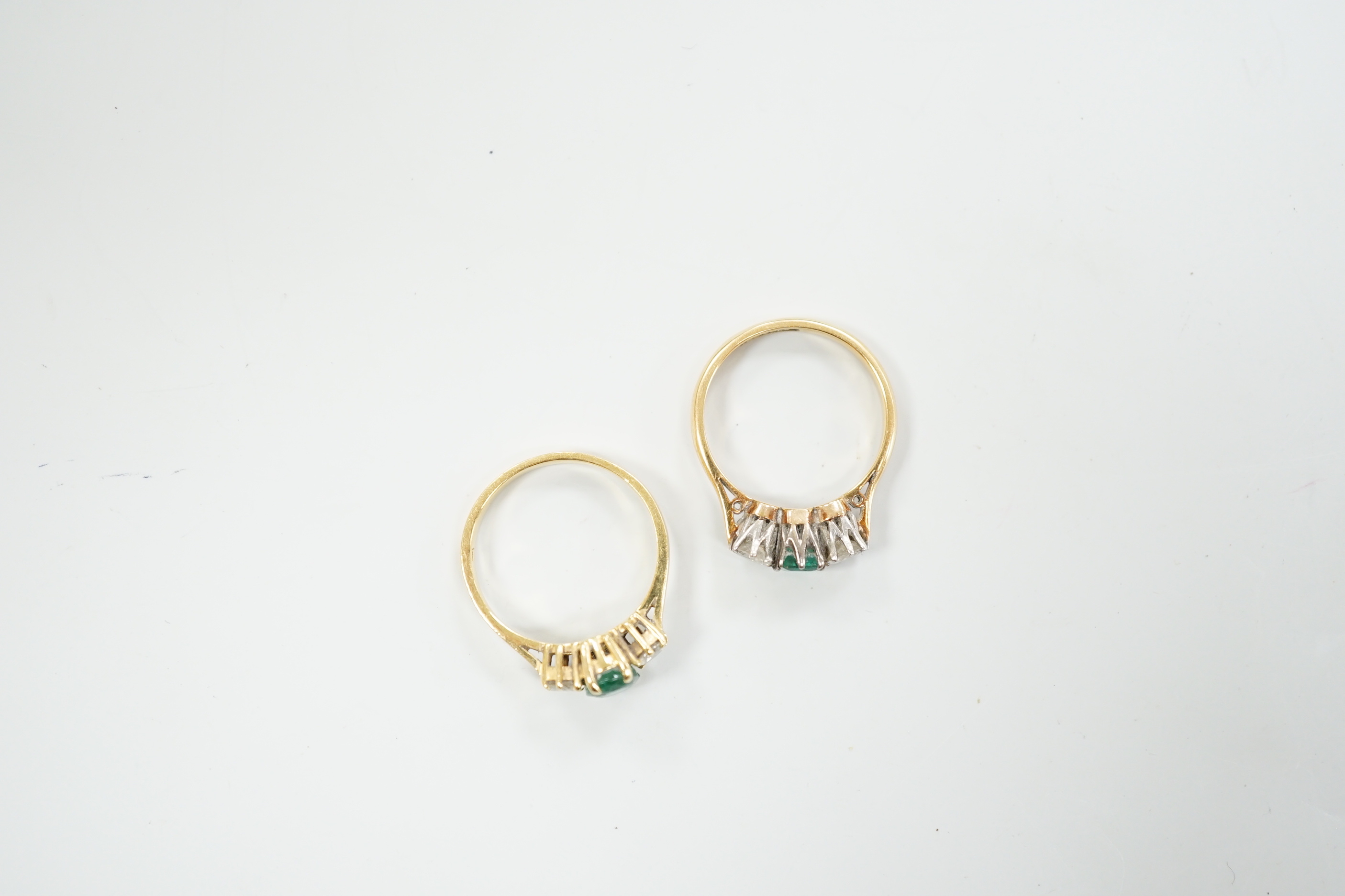 Two 18ct, single stone emerald and two stone diamond set rings, size M, gross weight, 5.5 grams.